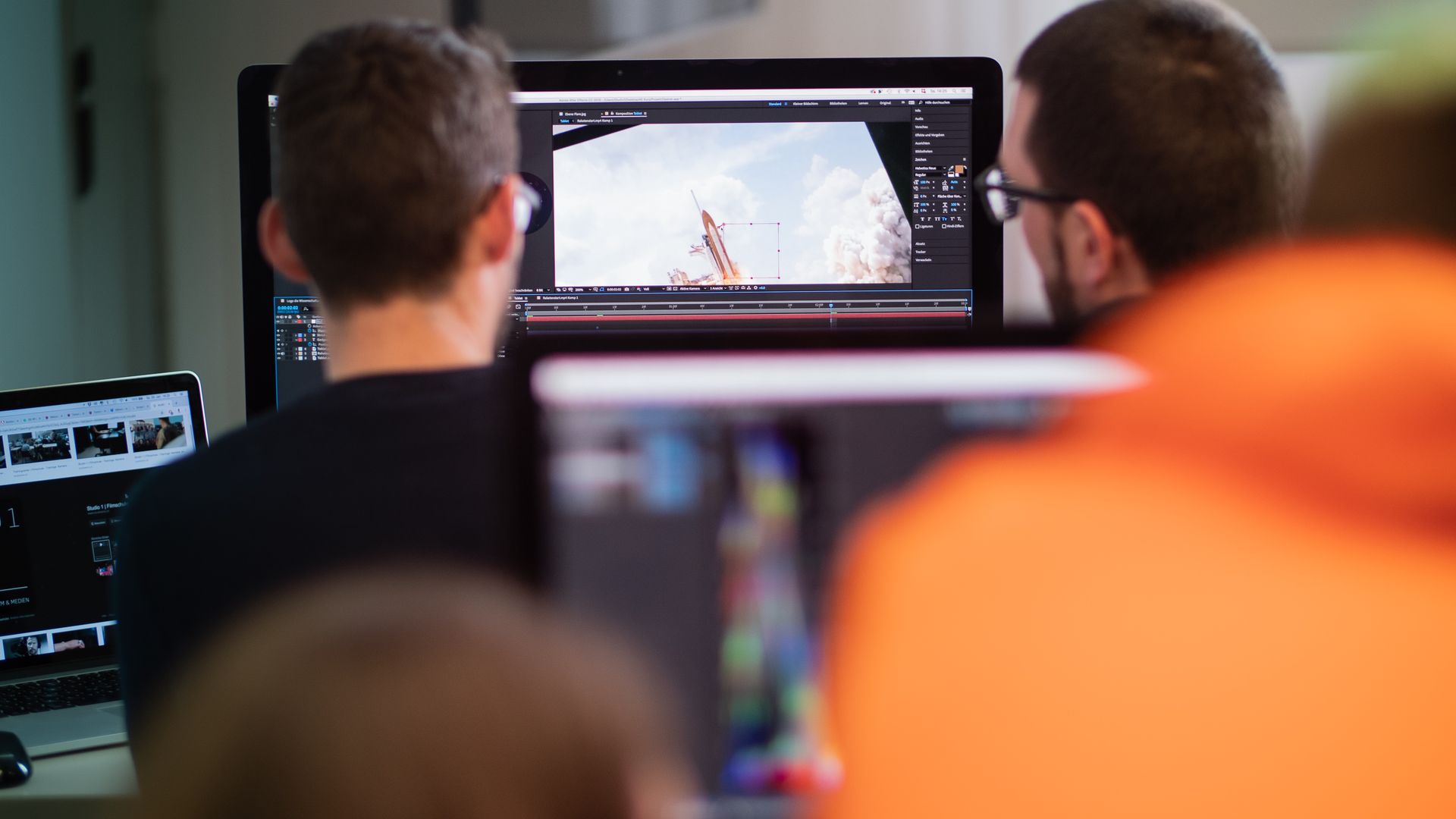 Zwei Kursteilnehmer betrachten im Schulungsraum von Studio 1 eine Aufnahme in After Effects