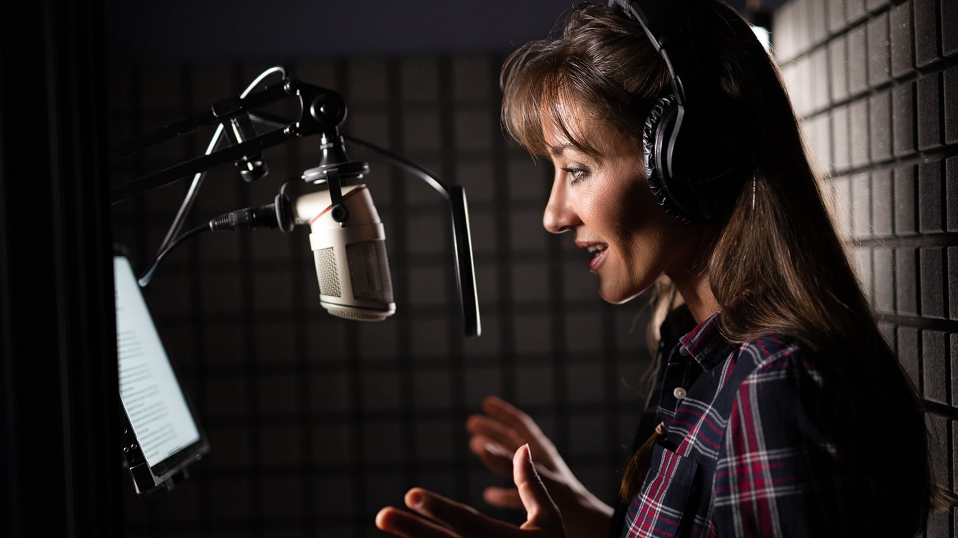 Sprecherin am Mikrofon im Tonstudio