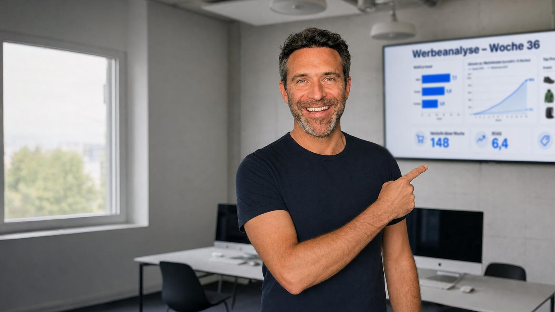 Roman Lehmann zeigt im Schulungsraum von Studio 1 auf eine Werbeanalyse auf dem Wandscreen