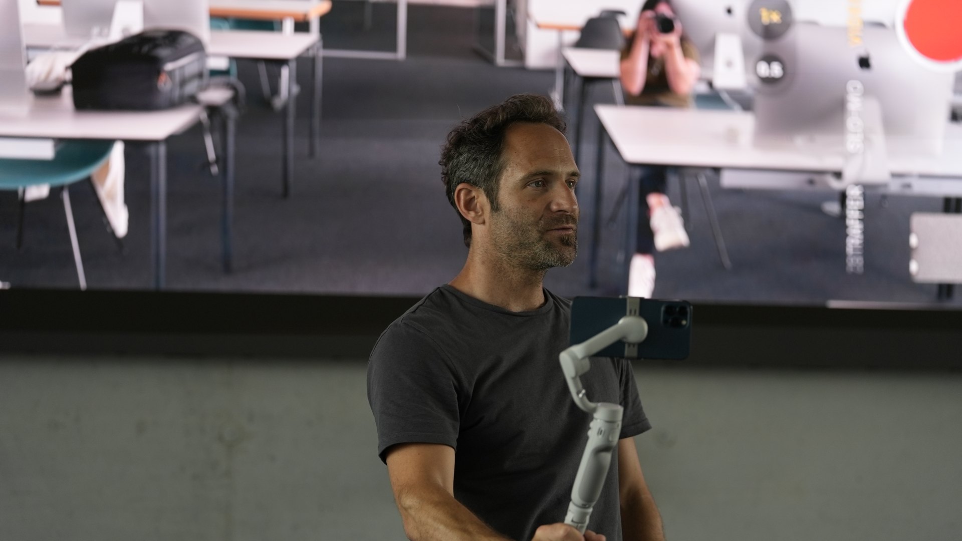 Roman Lehmann führt im Schulungsraum ein Smartphone auf einem Gimbal