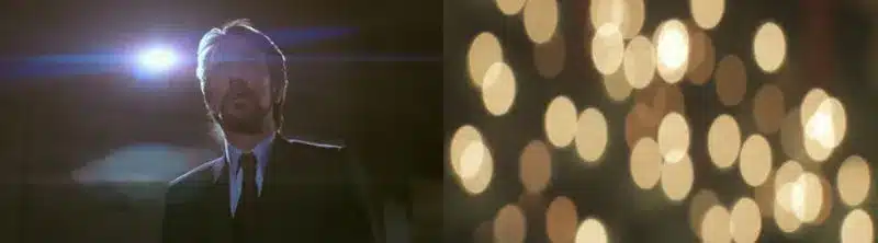 Person im Anzug im Scheinwerferlicht mit teilweise verschattetem Gesicht; warme Bokeh-Lichter leuchten sanft neben ihr. DAs Bild zeigt den Effekt der ovalen Bokeh und Lichtstreifen beim Verwenden von anamorphotischen Linsen