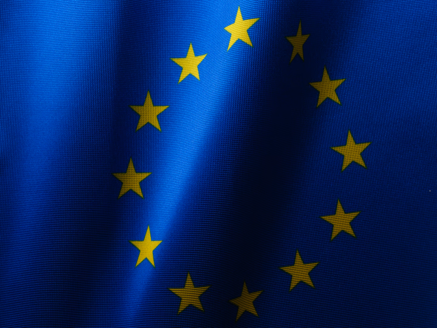 Europäische Flagge vor einem digitalen Interface mit KI-Symbolen